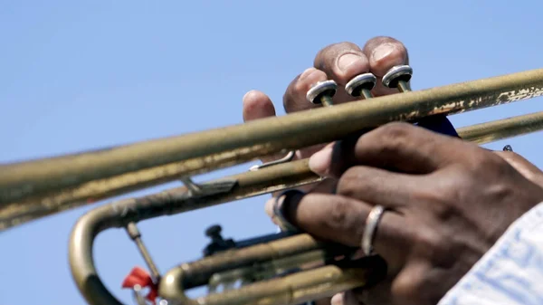 Egy trombitáló férfi kezének részletei. Felvétel. Közelkép egy fekete férfi kezéről, amint trombitál. — Stock Fotó
