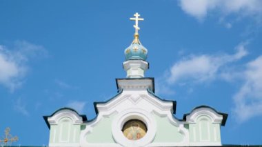 Altın ve mavi kubbede ortodoks haçı mavi bulutlu gökyüzüne karşı. Stok görüntüleri. Güneşli bir yaz gününde Azizler 'in onuruna güzel bir kilise..