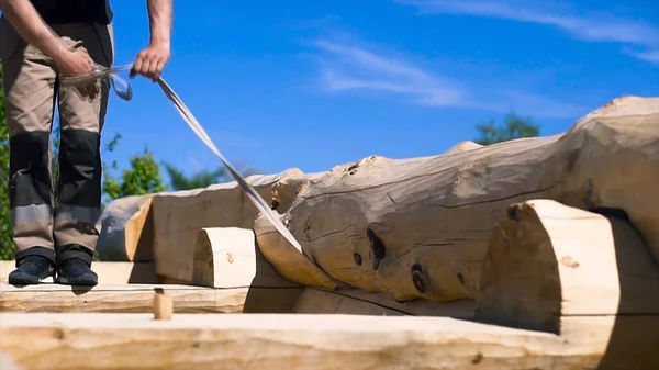 Close up of a professional carpenter legs walking on the wooden roof at the construction site. Clip. Roof worker building wooden house frame. — Stock Photo, Image