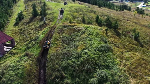 Vista aerea dall'alto del gruppo di persone che pattinano su un quad in una bella zona. Filmati delle scorte. Estremo concetto di sport motoristici, le persone che si muovono sul campo di erba verde . — Foto Stock