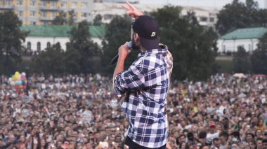 Rusya - Moskova, 10.02.2019: Rus hip hop ve rap müzik konseri bir solist ve tezahürat taraftarlarıyla. Başla. Sahnede sahne alan genç bir sanatçının arka görüntüsü..