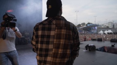 İngiltere - Londra, 09.01.2019: Rap müzik festivalinde hayranlarına el sallayan bir şarkıcının dikiz görüntüsü. Başla. Konserden önce genç adam..