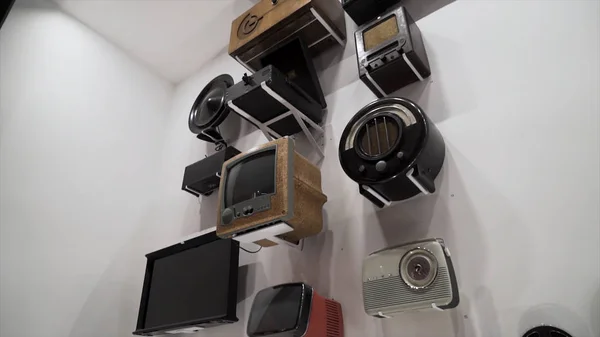 La mostra di ricevitori TV vintage, vecchi lettori audio e radio nel museo della tecnologia vintage. Azione. Dispositivi elettronici retrò appesi al muro in galleria . — Foto Stock