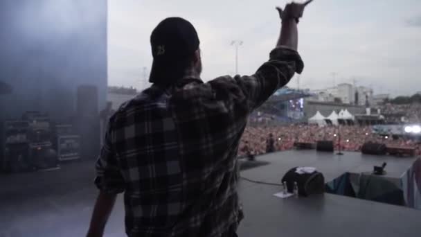 İngiltere - Londra, 09.01.2019: Rap müzik festivalinde hayranlarına el sallayan bir şarkıcının dikiz görüntüsü. Başla. Konserden önce genç adam.. — Stok video