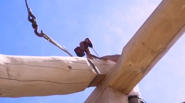 Elektrikli tornavidayla inşaat ustası. Şarjör. Yeni ahşap çatı katında ahşap malzemelerle çalışan profesyonel bir marangoz..