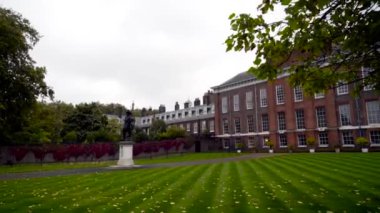 Clean yard with green lawn of old estate. Action. Old manor house with outside courtyard and perfect lawn in cloudy weather. Architecture and landscape of old estate