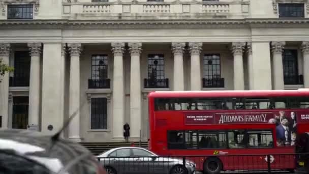 London, Storbritannien-september 2019: Stadstrafik med turistbuss på bakgrunden av gamla hus och byggnader. Börja. Röd buss är magnet för turister som besöker utlandet — Stockvideo