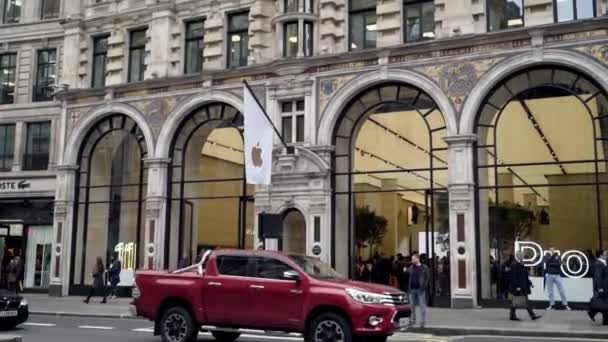 Londres, Gran Bretaña-septiembre de 2019: Apple Store se encuentra en el antiguo edificio arquitectónico de la ciudad europea. Acción. Turistas ambulantes y coches de tráfico en el fondo de la popular tienda de Apple — Vídeo de stock