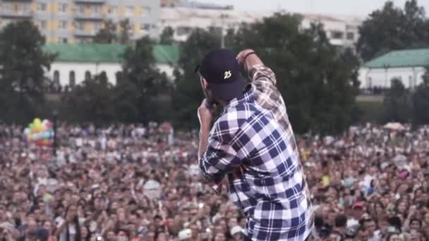 Russie - Moscou, 10.02.2019 : concert de hip hop russe et de rap en direct avec un chanteur et des fans enthousiastes. L'action. Vue arrière d'un jeune artiste se produisant sur scène à l'extérieur . — Video