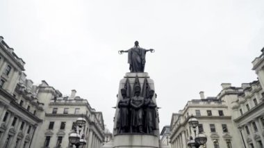 Londra, İngiltere-Eylül 2019: Bulutlu gökyüzünün arka planında eski Avrupa şehrinin merkezinde heykelleri olan anıt. Başla. Eski evlerin arka planında kompozisyon anıtı