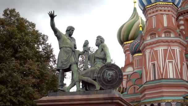 Monument with statues on background of St. Basils Cathedral. Action. Famous monument to Minin and Pozharsky on Moscow square on background of cloudy sky — Stock Video