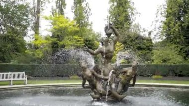 Park 'ta heykelleri olan eski güzel bir çeşme. Başla. Yeşil Park 'ın arka planındaki çeşmede deniz kızları olan heykel kompozisyonu