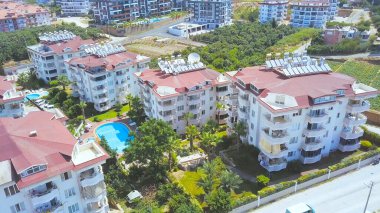 Yüzme havuzlu güzel otelin hava manzarası, Türkiye. Şarjör. Türkiye 'nin Akdeniz kıyısında yeşil tarlaları ve ağaçları olan sahil beldesi ve kasaba.