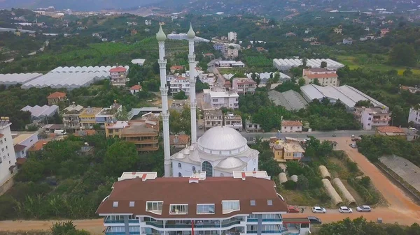 Vista aérea de la ciudad en Turquía, montaña alta y cielo nublado en el fondo. Clip. Pintoresco paisaje de las calles de la ciudad con la mezquita blanca, casas y árboles verdes . — Foto de Stock