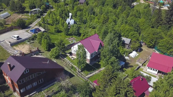 Vista de drone em uma pequena aldeia bonita com casas modernas e árvores verdes. Clipe. Paisagem de verão vista aérea das casas em área ecológica . — Fotografia de Stock