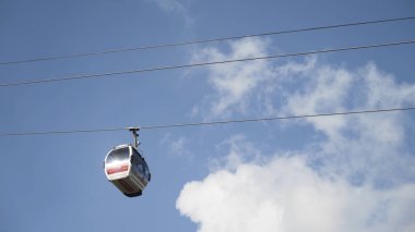 Füniküler kablo demiryolunun alt görüntüsü, mavi bulutlu gökyüzü arka planında hareket eden kamaralar. Başla. Yazın yavaş hareket eden yeni kulübeler..