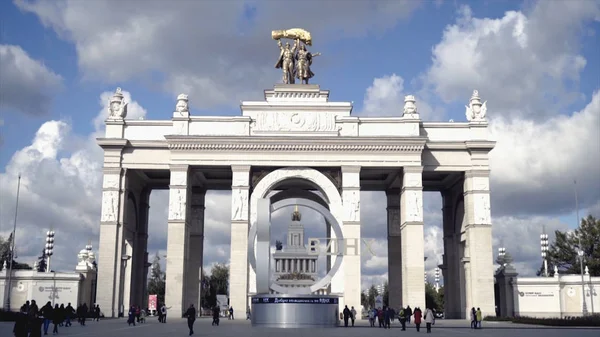 Architektura centrálního vchodu s kolonádou do parku. Akce. Turisté procházky na architektonické centrální vstup do parku na pozadí oblohy — Stock fotografie