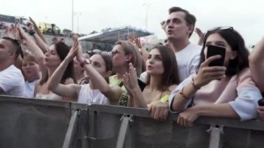 Nyon, İsviçre - 10.25.2019: Açık hava müzik festivalinin tadını çıkaran bir grup genç. Başla. Konser sırasında seyirciler tezahürat yapıyor ve şarkı söylüyor.