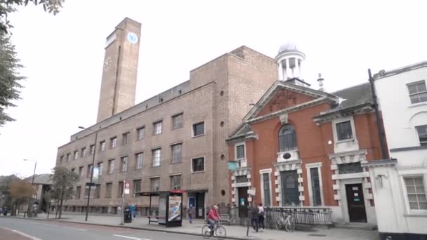 Londres, Gran Bretaña-septiembre de 2019: Viejas casas europeas con edificio con torre del reloj. Acción. Calle con gente y arquitectura antigua de casas de ciudad europea — Vídeos de Stock