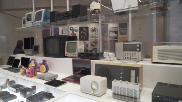 Лондон, Британия-сентябрь 2019 года: Винтажные электронные устройства в музейных окнах. Начали. Красивые старые электронные устройства, такие как магнитофоны и телевизоры, находятся в витринах винтажного музея — стоковое видео
