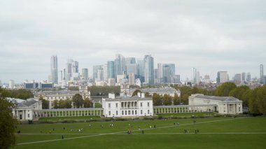 Şehrin arka planında eski mimari binası olan yeşil bir açıklık. Başla. Şehrin arka planında eski mimari binası olan yeşil açıklık