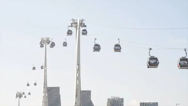 Bela vista do calçadão e da cidade moderna com teleférico. Acção. Belo panorama com teleférico passando sobre o canal no fundo da cidade moderna — Fotografia de Stock