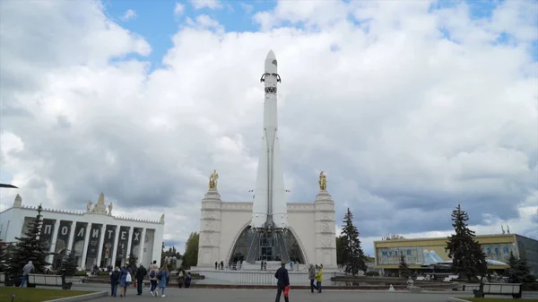 Russie, Moscou-Septembre, 2019 : Monument de fusée blanche sur fond de touristes à pied. L'action. Vue du bas de la grande fusée monument Est sur fond de ciel nuageux — Photo