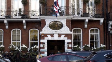 Turistlerle dolu eski bir Avrupa binasının dış cephesi. Başla. Eski Avrupa şehrinde, bulutlu havada turist ve arabaların bulunduğu bir yerleşim yeri.