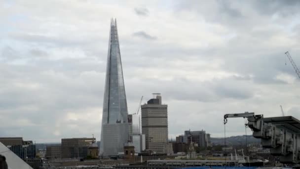 曇り空を背景に建物と現代の高層ビルのトップビュー。行動だ曇り空の街を背景に美しいガラス超高層ビル — ストック動画