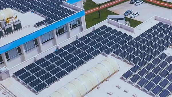 Вид с воздуха на солнечные фотоэлектрические панели на белом фоне крыши здания. Клип. Солнечные синие панели на крыше здания В современном городе концепция технологии . — стоковое фото