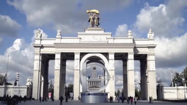 Architektur des zentralen Eingangs mit Kolonnade zum Park. Aktion. Touristen gehen am architektonischen Haupteingang zum Park im Hintergrund des Himmels — Stockvideo