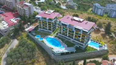 Tepenin tepesinde, büyük bir yüzme havuzu, tatil ve yaz seyahati konsepti olan lüks bir otel havası. - Sanat. Yeşil sahil şehrinin en üst manzarası.