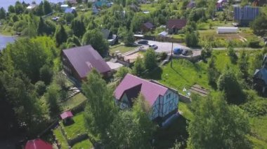 Yazın ağaçlarla çevrili yeşil tepenin üzerindeki güzel bir kır evinin havadan manzarası. Şarjör. Modern bir köy manzarası, ekoloji kavramı.