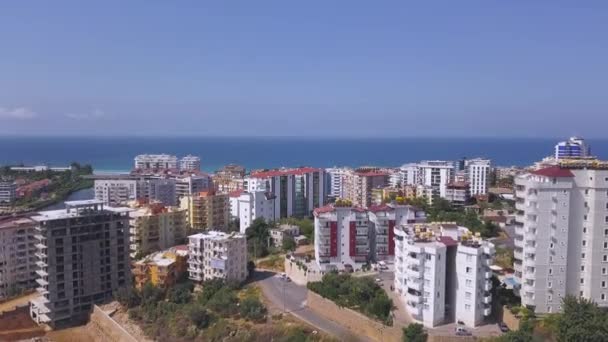 Adembenemend uitzicht op het zomerlandschap met de stad in Turkije aan zee. Kunst. Veel hoge gebouwen en woonhuizen in de voorkant van de blauwe eindeloze zee. — Stockvideo