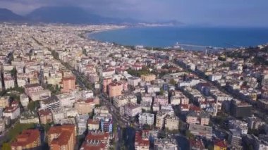 Okyanus kıyısının ve bulutlu mavi gökyüzü arka planında şehir evlerinin nefes kesen manzarası. - Sanat. Okyanus kıyıları ve şehir sokaklarıyla muhteşem bir manzara..