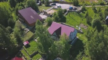 Yazlık köydeki evler ve yerleşim yerlerinin havadan görünüşü. Şarjör. Ekolojik alanda inşa edilen parlak pembe kır evlerinin üst manzarası.