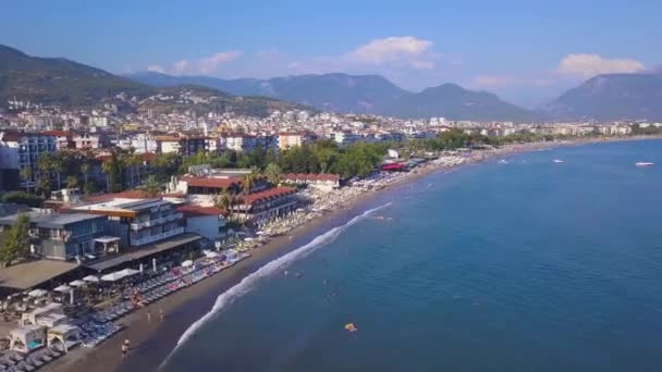 Luftaufnahme des schönen Strandes in Spanien. Kunst. Blick von der Drohne über die Meeresküste mit vielen Menschen, die schwimmen und Spaß im blauen Wasser haben. — Stockvideo