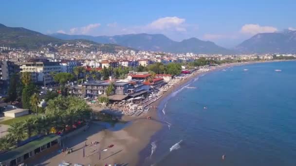 Luftaufnahme des schönen Strandes in Spanien. Kunst. Blick von der Drohne über die Meeresküste mit vielen Menschen, die schwimmen und Spaß im blauen Wasser haben. — Stockvideo