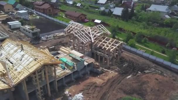 Nytt hem träkonstruktion uppifrån i landsbygdsområdet. Klipp. Flygfoto över sommar grön by och ett nytt trä timmerhus. — Stockvideo