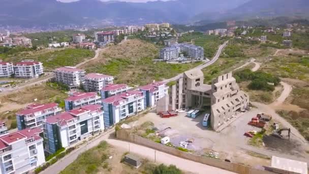 Aerial view of hilly area and houses of the city. Art. Southern town roofs surrounded by green bushes and trees, nature and ecological place to live. — Stock Video