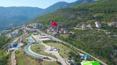 Yeşil ormanlık arka planda kırmızı Türk bayrağı dalgalanırken. - Sanat. Bir dağ yamacındaki gözlem güvertesinin havası..