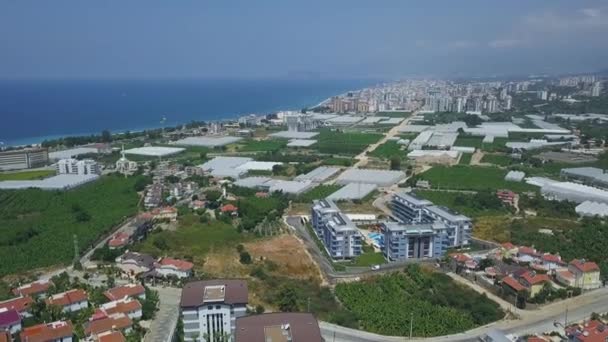 Luchtfoto adembenemend uitzicht op mooie stad Alanya in Turkije, toerisme en vakantie aan zee concept. Kunst. Vliegen over de kuststad op blauwe lucht en de horizon achtergrond. — Stockvideo