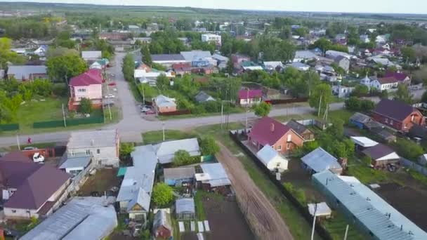 Αεροφωτογραφία του σύγχρονου χωριού με χαριτωμένα σπίτια και καταπράσινα χωράφια. Κλιπ. Πετώντας κατά μήκος του δρόμου του χωριού σε μια ηλιόλουστη καλοκαιρινή μέρα. — Αρχείο Βίντεο