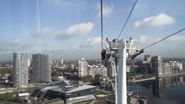 Pintoresca vista de la ciudad desde el interior de la cabina de teleferic. Acción. Paisaje de un moderno edificio de la ciudad y el río, moviéndose dentro de la cabaña, teleférico . — Vídeos de Stock