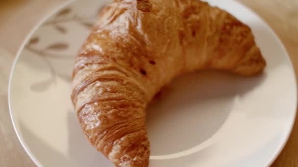 HomeMade croissant on the plate. Stock footage. Delicious croissant on a plate in the pastry shop. Baking croissants home kitchen. Having breakfast concept — Stock Video