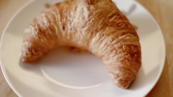 Zelfgemaakte croissant op het bord. Voorraadbeelden. Heerlijke croissant op een bord in de banketbakkerij. croissants thuiskeuken bakken. Ontbijtconcept — Stockvideo