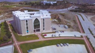 Üniversite binasının üzerinde uçmak ve Türkiye 'de kampüsün ana girişi, eğitim kavramı. - Sanat. Cam sıra dışı pencereli beyaz binanın havası..