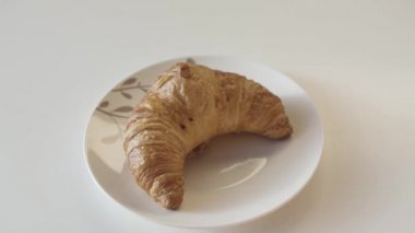 Fransız kruvasanı tabakta, yaklaş. Stok görüntüleri. Lezzetli taze pişmiş kruvasan ahşap masanın arkasında, tabakta duruyor..