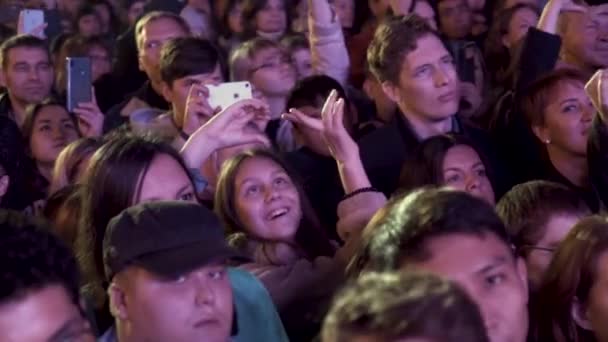 Germania - Berlin, 09.13.2019: fanii fericiți ai muzicii zâmbind și făcând fotografii și videoclipuri ale spectacolului noaptea. Acţiune. Concert live în aer liber și mulțime fericită . — Videoclip de stoc