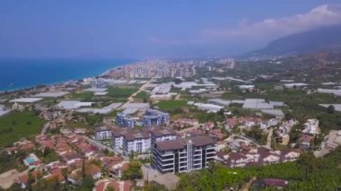 Sahile, gök mavisi denize ve sahile uzanan güzel tepelerin havadan manzarası. Şarjör. Küçük yeşil kıyı kasabası Avrupa 'nın en popüler tatil beldesidir..